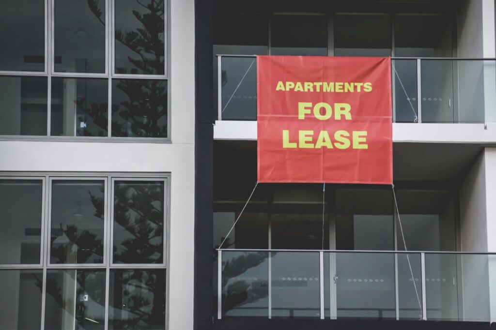 Apartments For Lease signage, real estate, red sign hanging from a balcony