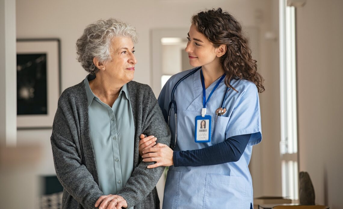 Caregiver assist senior woman at home