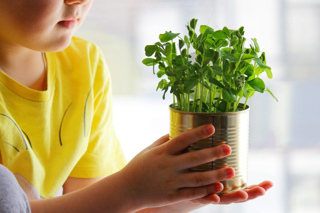 a child is holding a jar of green peas