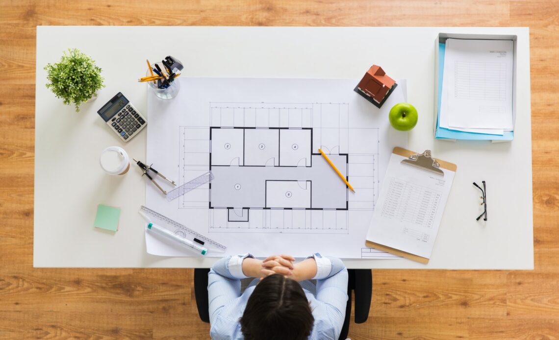 architect with house blueprint at office