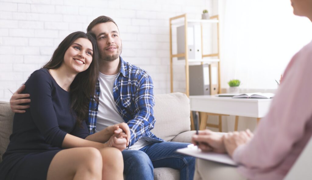 Cheerful spouses bonding at consultation with psychologist