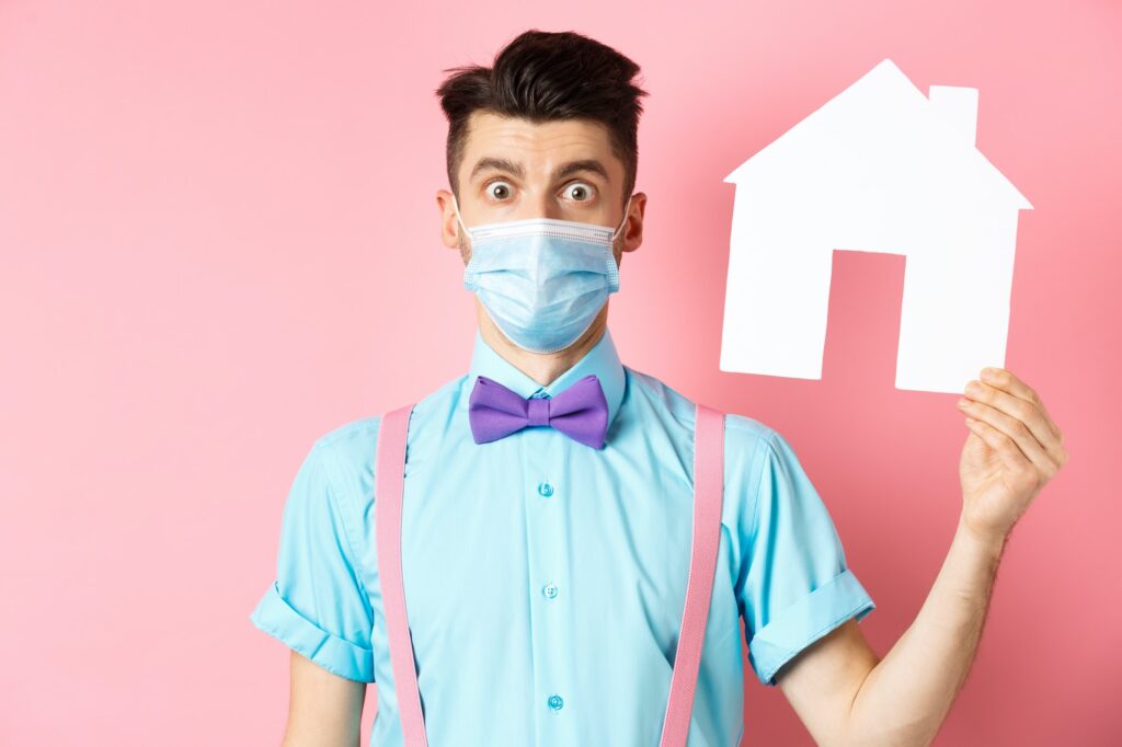 Covid, pandemic and real estate concept. Confused guy in medical mask searching property, showing