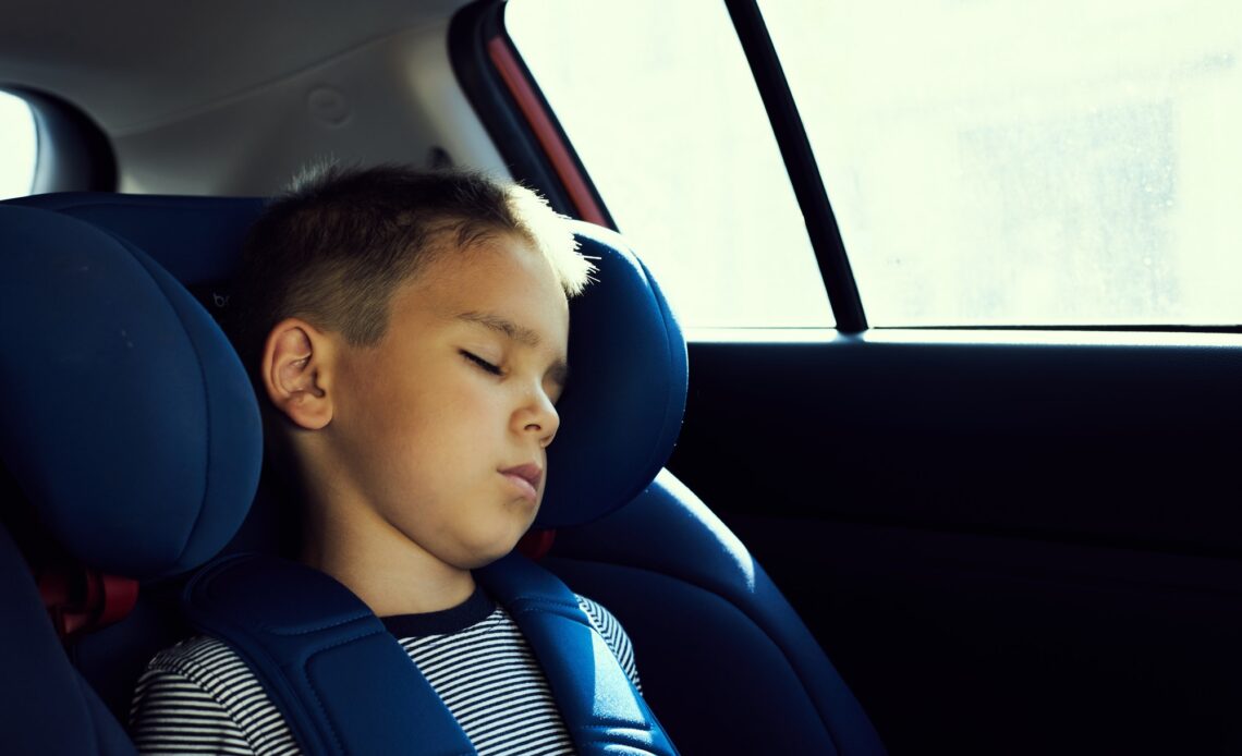 Little boy sleeping in a car seat