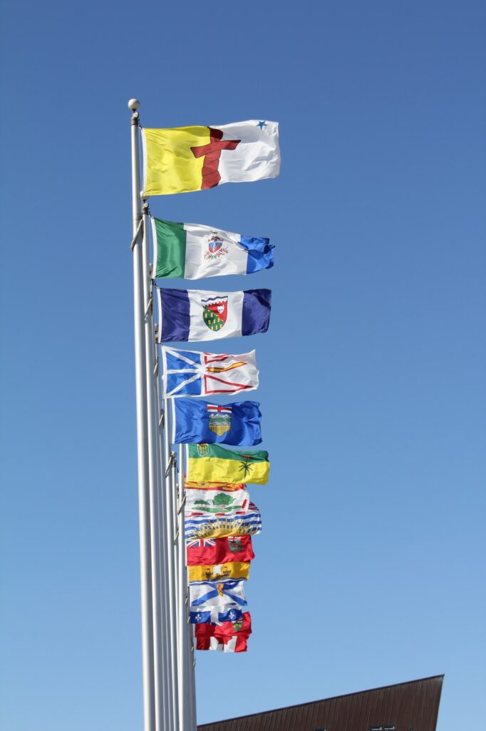 Row of flags — All of the canadian provinces flag’s and canadian flag - with blue sky in background