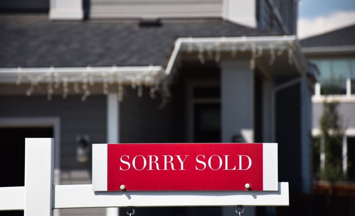 Sorry Sold real estate sign in front of a house