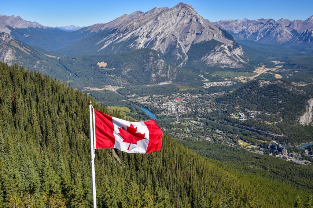 Canada flag with Canadian rocky mountain at the background