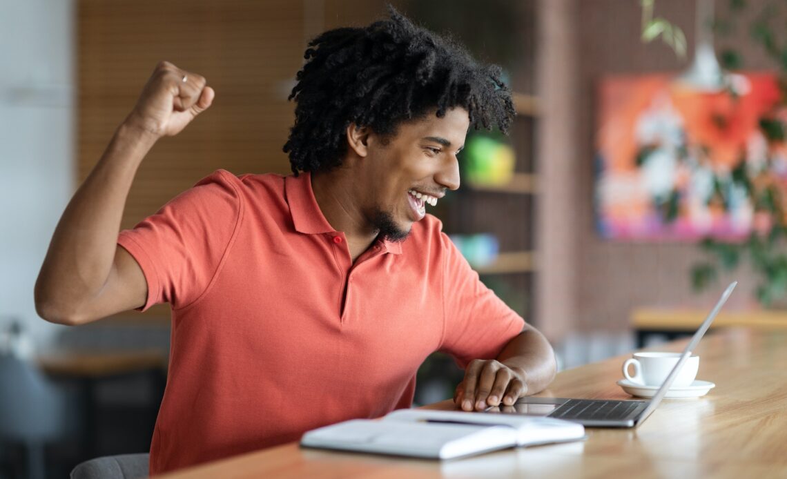 Good News. Emotional Black Man Looking At Laptop Screen And Celenbrating Success